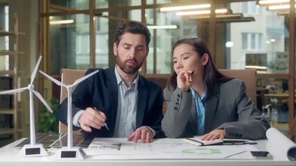 Caucasian Korean business workers environment eco discussion startup working windmills model businessman businesswoman talking green energy wind turbine alternative sources woman man indoors office - Powered by Adobe