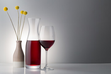 red wine with dried floweron bright background.