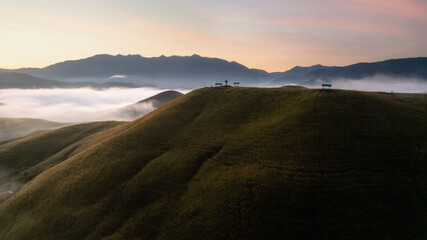Fototapeta premium Aerial View landscape of bright sunrise over misty golden meadow on morning. Phu Hua Lon, Xaysomboun, Laos.
