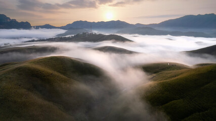 Aerial View landscape of bright sunrise over misty  golden meadow on morning. Phu Hua Lon, Xaysomboun, Laos.