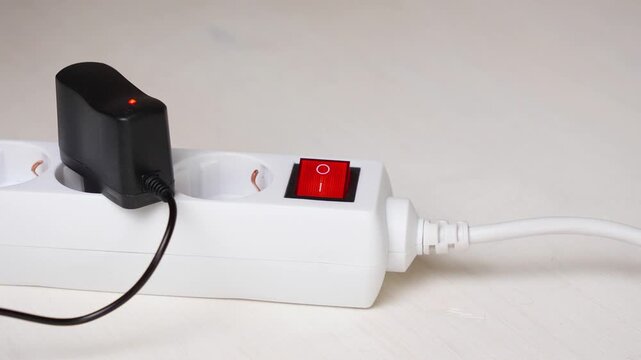 white surge protector with a red button