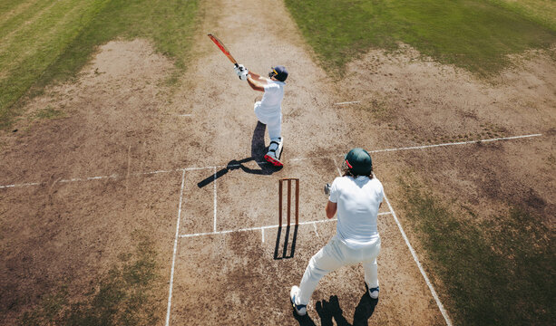 Aerial view of cricket players batting with wicket keeper on field