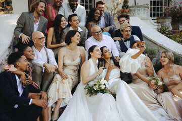 Joyful wedding moment with two brides surrounded by their loved ones