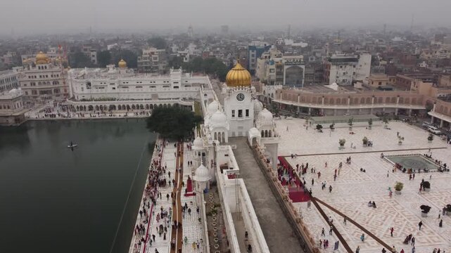 Aerial view of the serene Golden Temple complex, with its gleaming golden dome reflecting in the holy water, Katra Ahluwalia, Punjab, India.