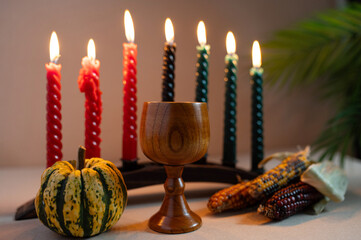 Happy Kwanzaa. Seven candles red, black and green on a natural wooden background. Harvest and...