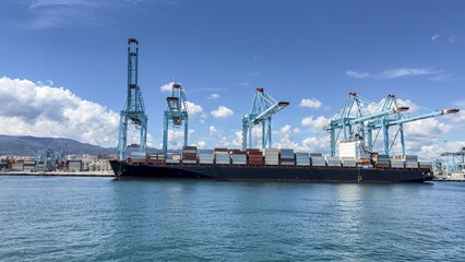 Industrial port with cranes unloading cargo containers