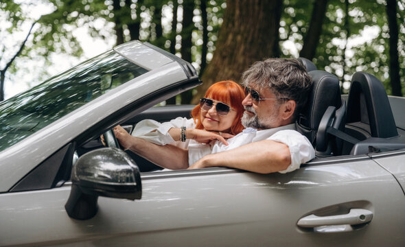Feeling good, going for vacation. Senior couple driving convertible cabriolet car