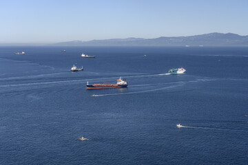 Obraz premium Cargo and passenger ships navigating the Strait of Gibraltar