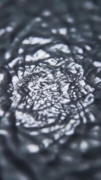 Close-up macro shot of a metallic silver surface where subsurface light shifts cause intricate resonant patterns to ripple and warp continuously commercial, technology, contemporary