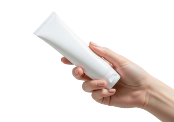 Female hand holding a white tube of cream or lotion isolated on transparent background, demonstrating skincare and beauty product application