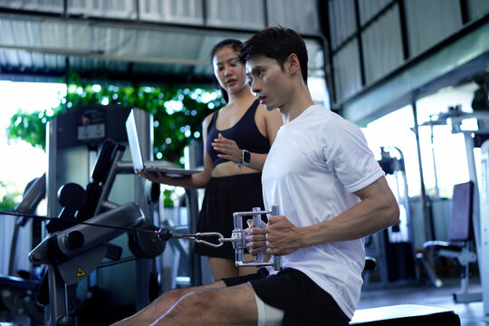 Shoulder pull down machine. Fitness man working out lat pulldown training at gym. Upper body strength exercise for the upper back. - Powered by Adobe