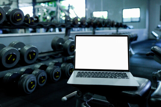 Laptop with blank screen on blurred gym background - Powered by Adobe