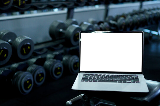 Laptop with blank screen on blurred gym background