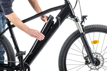 Unrecognizable male hands installing the battery on an electric bicycle