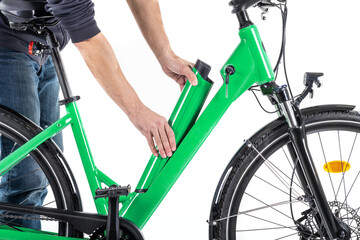 Unrecognizable male hands installing the battery on an electric bicycle