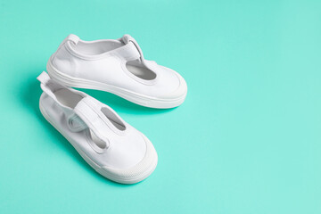 Pair of stylish kid's shoes on turquoise background. Space for text