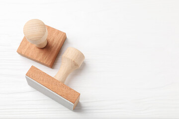 Two wooden stamps on white table, top view. Space for text