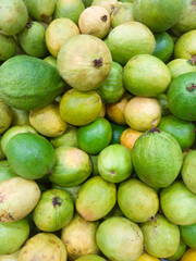 A pile of guavas stacked on a supermarket shelf