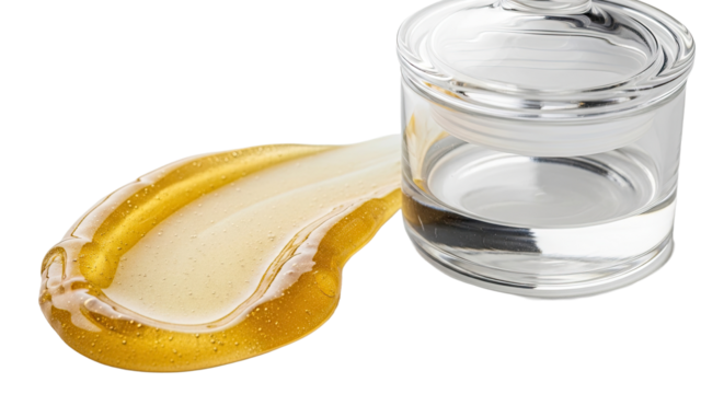 Smear of golden gel beside transparent glass container on white
