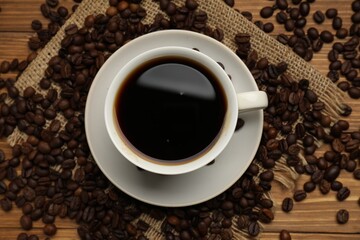 Aromatic coffee in cup and beans on wooden table, flat lay