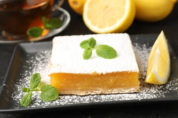 Tasty lemon bar with mint, fresh fruits and tea on table, closeup