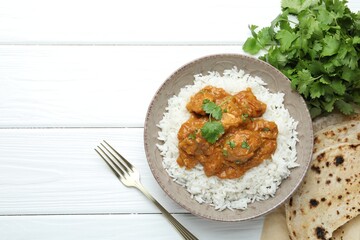 Delicious chicken tikka masala with rice and cilantro on white wooden table, flat lay. Space for text