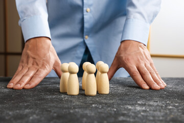 Man with human figures at black table, closeup