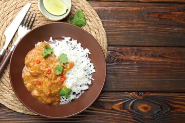 Chicken tikka masala with rice served on wooden table, flat lay. Space for text