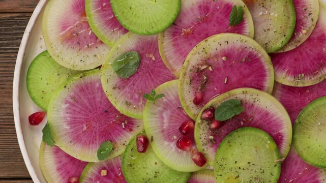 watermelon radish daikon salad on white plate food top zoom