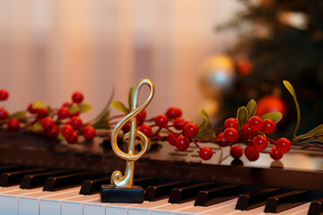 Golden treble clef and Christmas decor on piano indoors, closeup