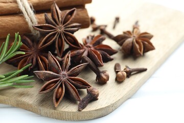 Mulled wine spices. Anise stars, cinnamon sticks, cloves and fresh rosemary on white table, closeup