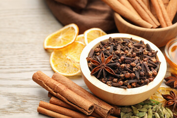 Different spices and dry orange slices for mulled wine on wooden table, closeup