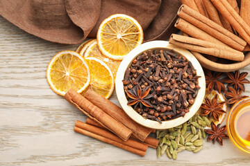 Different spices, dry orange slices and honey for mulled wine on wooden table, flat lay
