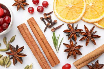 Different spices, cranberries, dry orange slices and fresh rosemary for mulled wine on white table, flat lay