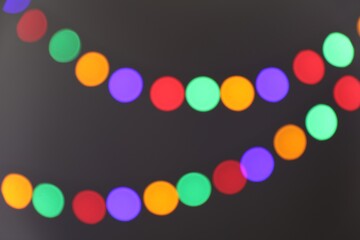 Bright Christmas lights on gray background, bokeh effect