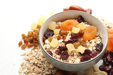 Making granola. Oat flakes, dried fruits and other ingredients on white table, closeup
