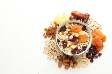 Making granola. Oat flakes, dried fruits and other ingredients on white table, flat lay. Space for text