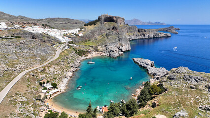 Aerial drone photo of elliptical shaped paradise bay and chapel of Saint Paul, featuring organized beach and crystal clear calm turquoise waters, Rhodes island, Dodecanese, Greece