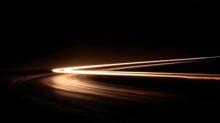 Long exposure of car light trails on dark curved road at night