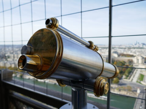 Vintage metal telescope on Eiffel Tower for tourists viewing Paris city