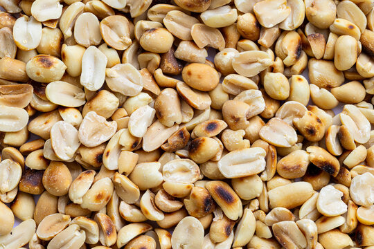 Close-up macro of roasted peanuts,Close up of roasted peanuts background,Roasted and salted peanuts, snack food, background, from above  - Powered by Adobe