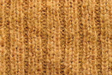 Macro close-up of brown wool sweater fabric detail texture,A close up of a knitted item with a brown color. The item is made of yarn and has a pattern of loops and knots.