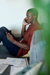 Fototapeta na wymiar African man talking on his phone while working at home