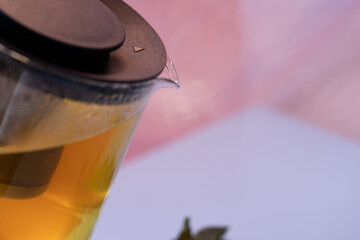 Close view of teapot lid and spout with beads of condensation; selective focus and a pastel backdrop frame brewing details for natural tea branding, product design and warm lifestyle.