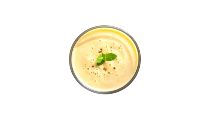 Creamy soup in glass, garnished with herb, red pepper, view from above