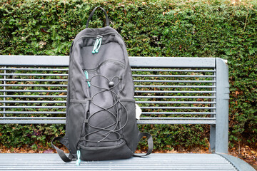 Outdoor. Black backpack on metal bench