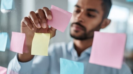 Young african male planning with colorful sticky notes in office