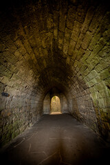Fototapeta premium Ancient castle underground cellar of warkworth castle,, Northumberland. UK. Stone walls and cold, damp floor.