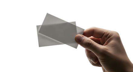Hand holding two white squares against a black background in studio lighting
