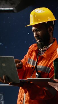 Vertical Video Professional military operative communicates via radio on offshore platform, coordinating with intelligence service units to prevent terrorist threats and ensure mission safety. Camera